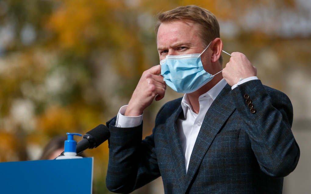 Minister of Health Tyler Shandro, removes his made-in-Calgary mask while announcing a new agreement between Alberta Health Services and a local manufacturer to produce medical equipment, in Calgary, Alta., Wednesday, Oct. 7, 2020.THE CANADIAN PRESS/Jeff McIntosh