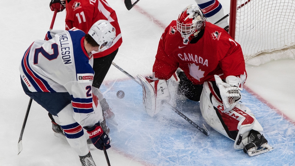 Canada goalie Devon Levi (1) makes the save on United States' Drew Helleson (2) during second period IIHF World Junior Hockey Championship gold medal game action in Edmonton on Tuesday, January 5, 2021. THE CANADIAN PRESS/Jason Franson 