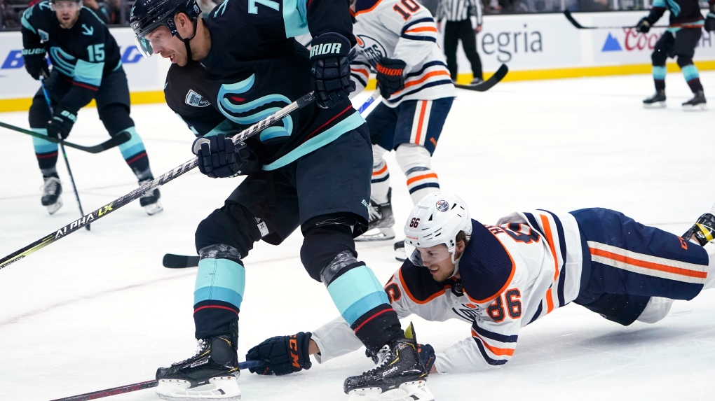 Edmonton Oilers defenseman Philip Broberg (86) dives toward the puck as Seattle Kraken right wing Joonas Donskoi (72) skates past during the first period of an NHL hockey game Friday, Dec. 3, 2021, in Seattle (AP Photo/Elaine Thompson).