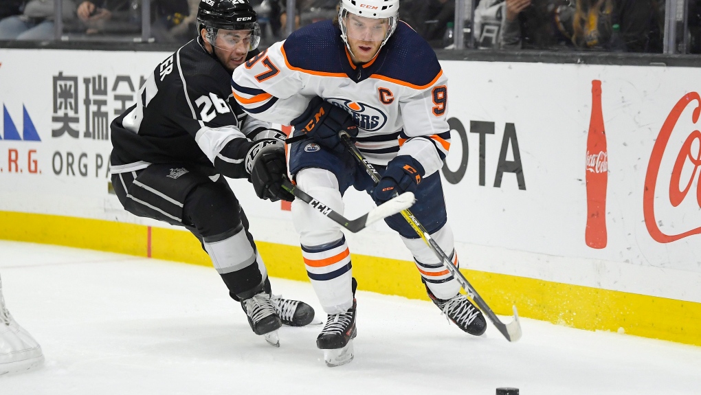 Edmonton Oilers center Connor McDavid, right, moves the puck while under pressure from Los Angeles Kings defenseman Sean Walker during the third period of an NHL hockey game Sunday, Feb. 23, 2020, in Los Angeles. The Oilers won 4-2 (AP Photo/Mark J. Terrill).