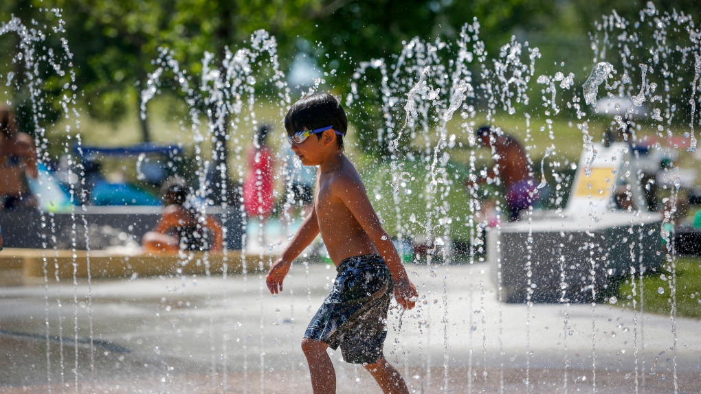 A young boy runs through a fountain at a splash park trying to beat the heat in Calgary, Alta., Wednesday, June 30, 2021. (THE CANADIAN PRESS / Jeff McIntosh)