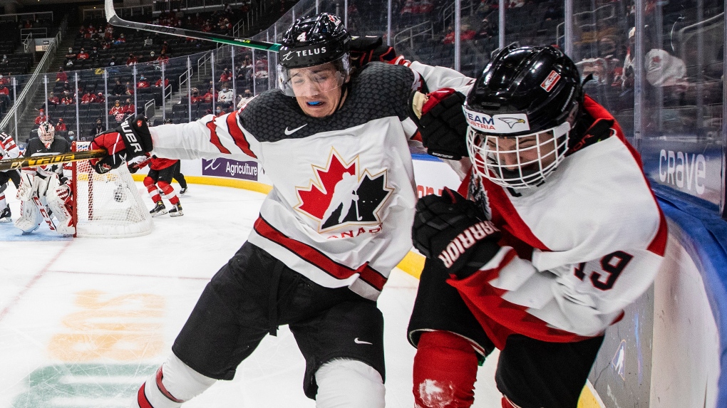 Canada's Carson Lambos (4) checks Austria's Marco Kasper (19) during third period IIHF World Junior Hockey Championship action in Edmonton on Tuesday, December 28, 2021. THE CANADIAN PRESS/Jason Franson 
