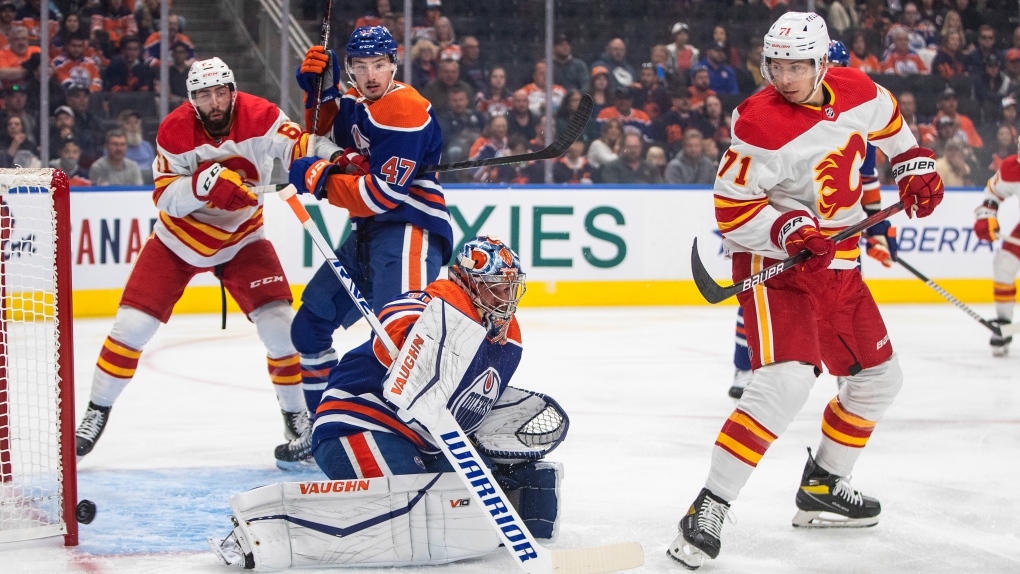 Calgary Flames' Walker Duehr (71) screens Edmonton Oilers' goalie Jack Campbell (36) as he makes the save during first period pre-season action in Edmonton on Friday, September 30, 2022. (THE CANADIAN PRESS/Jason Franson)
