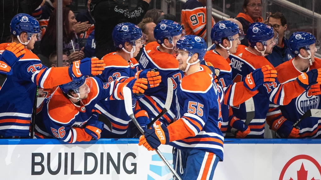 Edmonton Oilers' Dylan Holloway (55) celebrates a goal against the Vancouver Canucks during first period preseason action in Edmonton on Monday, October 3, 2022.THE CANADIAN PRESS/Jason Franson