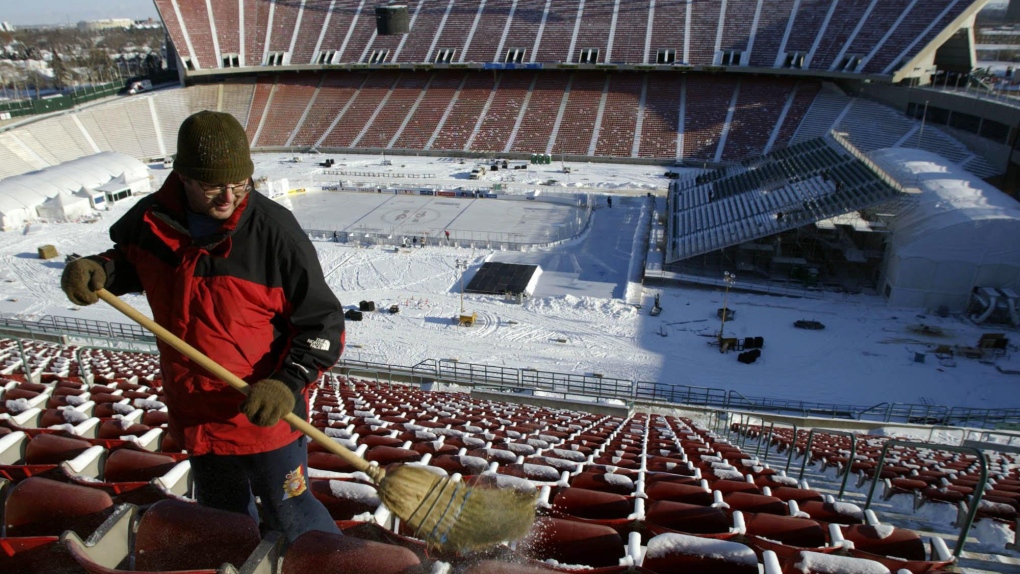 Dave Blais clears snow from the seats in the upper bowl of Commonwealth Stadium in preparation for the Heritage Classic outdoor hockey game Thursday, November 20, 2003 in Edmonton.(CP PHOTO/Adrian Wyld)
