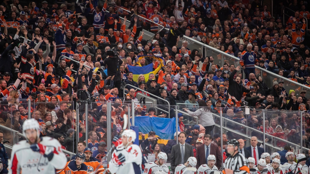 Fans wave Ukrainian flags during Washington Capitals and Edmonton Oilers NHL hockey action in Edmonton, Alta., on Wednesday March 9, 2022. The Oilers won 4-3 in overtime (The Canadian Press/Amber Bracken).
