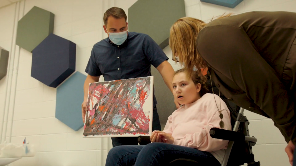 Olivia Terry shows off a painting she created with brain computer interface technology. 