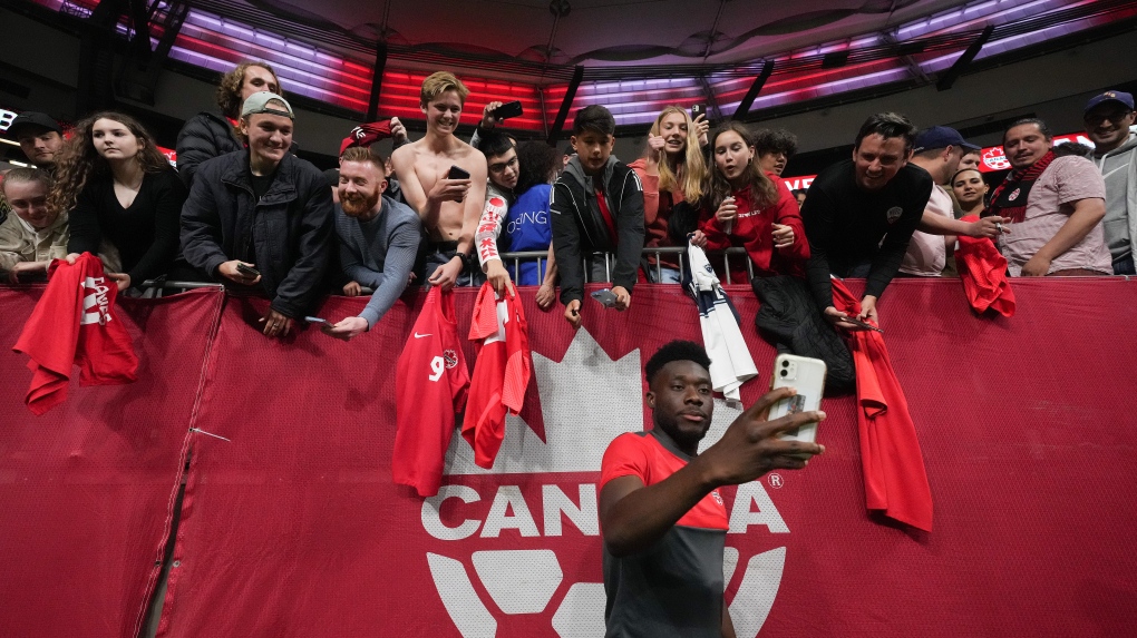 Canada's Alphonso Davies poses for selfies with fans after Canada defeated Curacao during a CONCACAF Nations League soccer match, in Vancouver, on Thursday, June 9, 2022. THE CANADIAN PRESS/Darryl Dyck