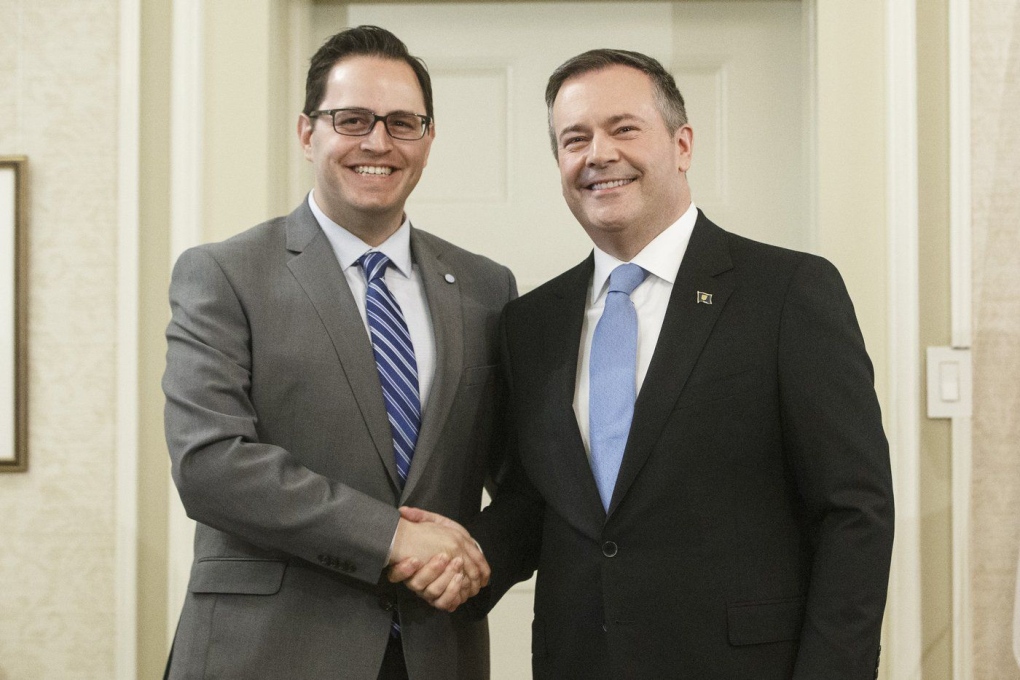 Alberta Premier Jason Kenney shakes hands with Demetrios Nicolaides, minister of advanced education, after being sworn into office, in Edmonton on April 30, 2019. The Alberta government has upped the ante in its fight with Athabasca University, directing the online-oriented school to get busy making sure more staff work in the small northern town or risk losing millions of dollars in funding. (THE CANADIAN PRESS/Jason Franson)