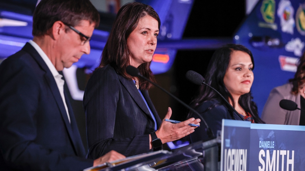 Danielle Smith, centre, makes a comment as Todd Loewen, left, and Rajan Sawhney listen during the United Conservative Party of Alberta leadership candidate's debate in Medicine Hat, Alta., Wednesday, July 27, 2022.THE CANADIAN PRESS/Jeff McIntosh