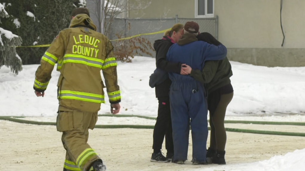 People embrace at the scene of a fatal house fire on Brazeau Drive in Devon, Alta., on January 10, 2023 (Matt Marshall/CTV News Edmonton.)