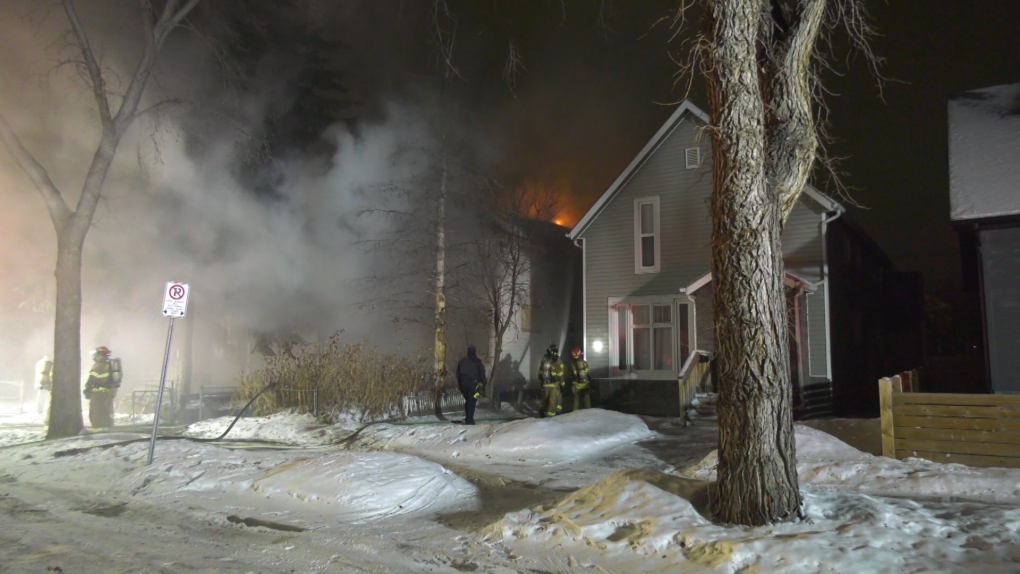 Flames and heavy smoke could be seen coming from the roof of a house near 110 Avenue and 96 Street on Saturday Jan. 28, 2023. (CTV News Edmonton/Sean McClune)