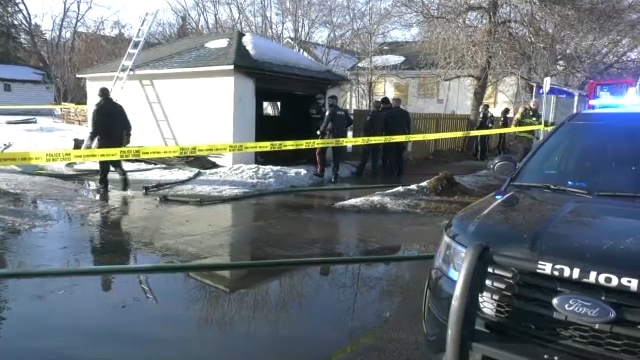 Police and firefighters probe a south central Edmonton garage after a fire on Saturday, March 18, 2023 (CTV News Edmonton/Galen McDougall).