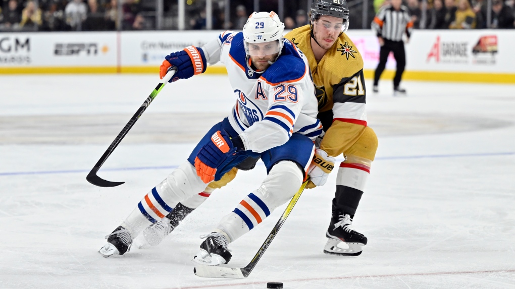 Edmonton Oilers center Leon Draisaitl (29) and Vegas Golden Knights center Brett Howden (21) battle for the puck during the second period of an NHL hockey game Tuesday, Feb. 6, 2024, in Las Vegas. (AP Photo/David Becker)
