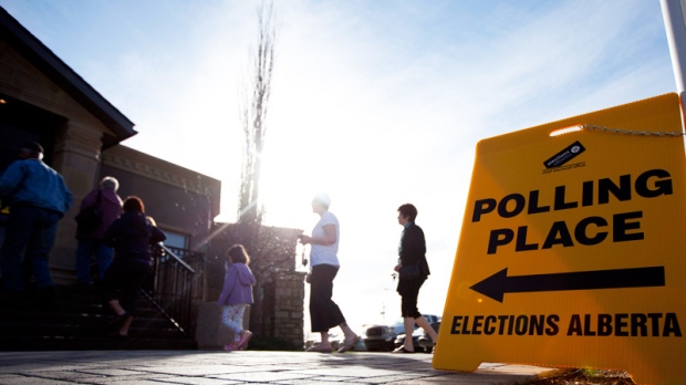 Voters line up at a polling station in High River, Alberta to cast her ballot for the Alberta election Monday. (Jonathan Hayward / THE CANADIAN PRESS)